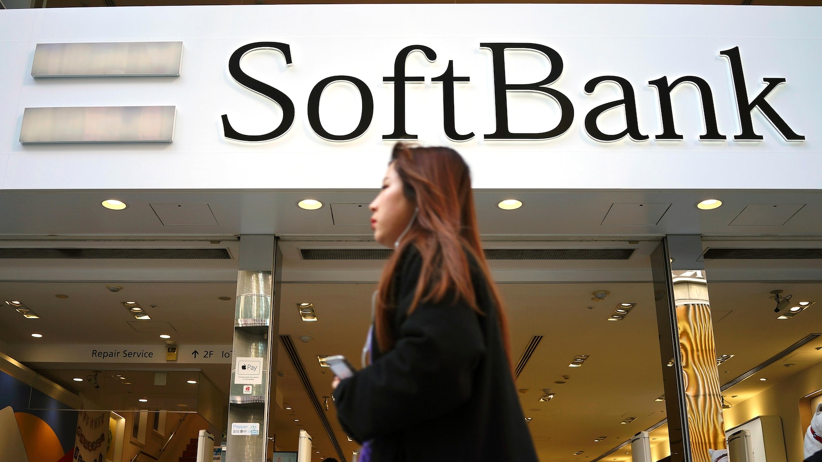 Japan’s SoftBank Group trims investment losses but remains in red for fiscal year